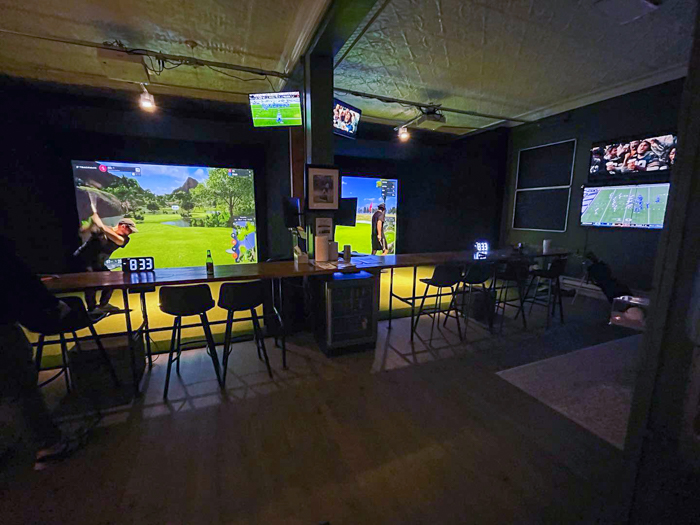 A photo of golfers playing in a indoor golf league of simulator golf at Miller Mulligans indoor golf simulator located in the South Hills of Pittsburgh, Pa